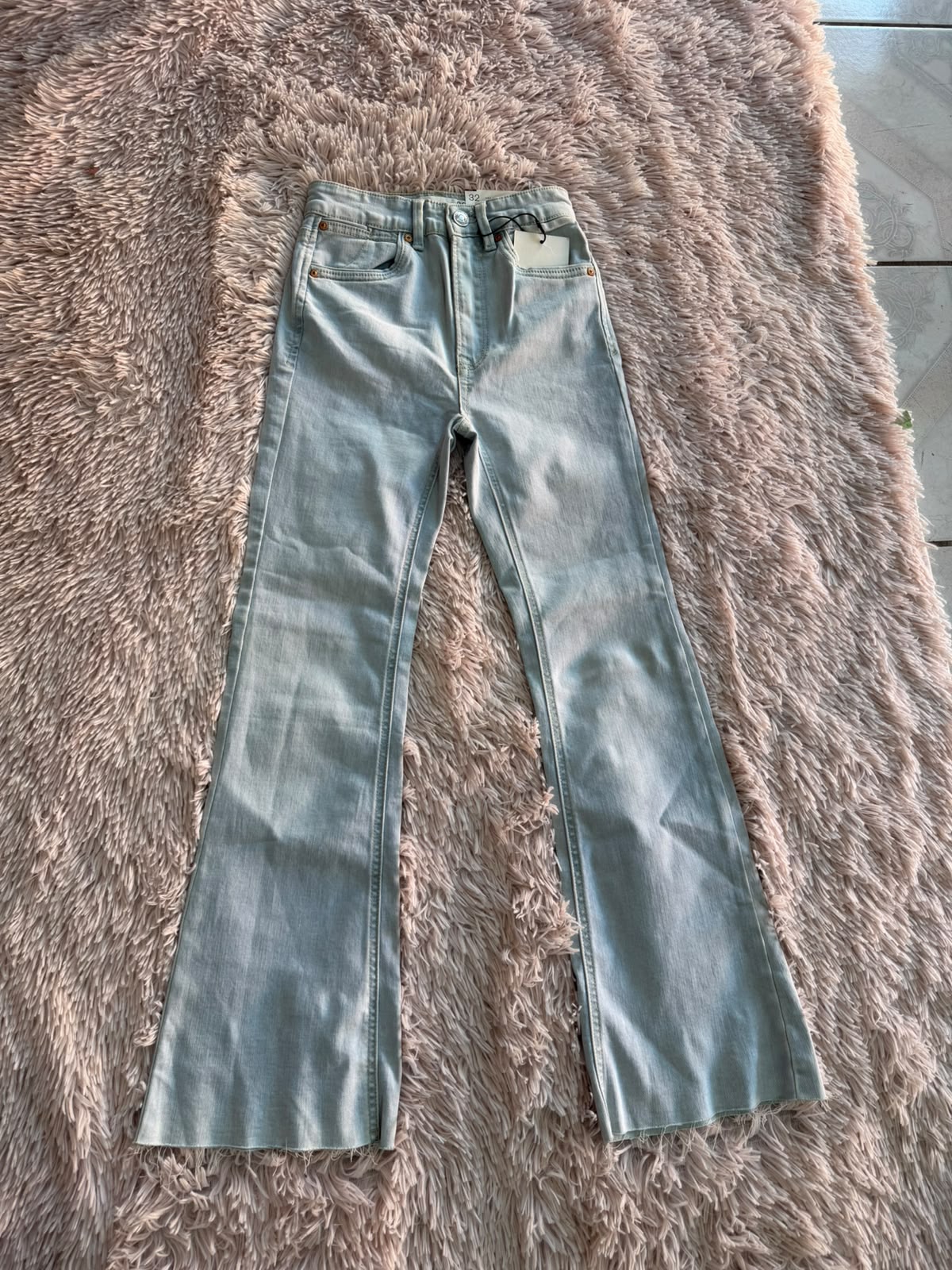 Jeans azul claro acampanados con bajo deshilachado