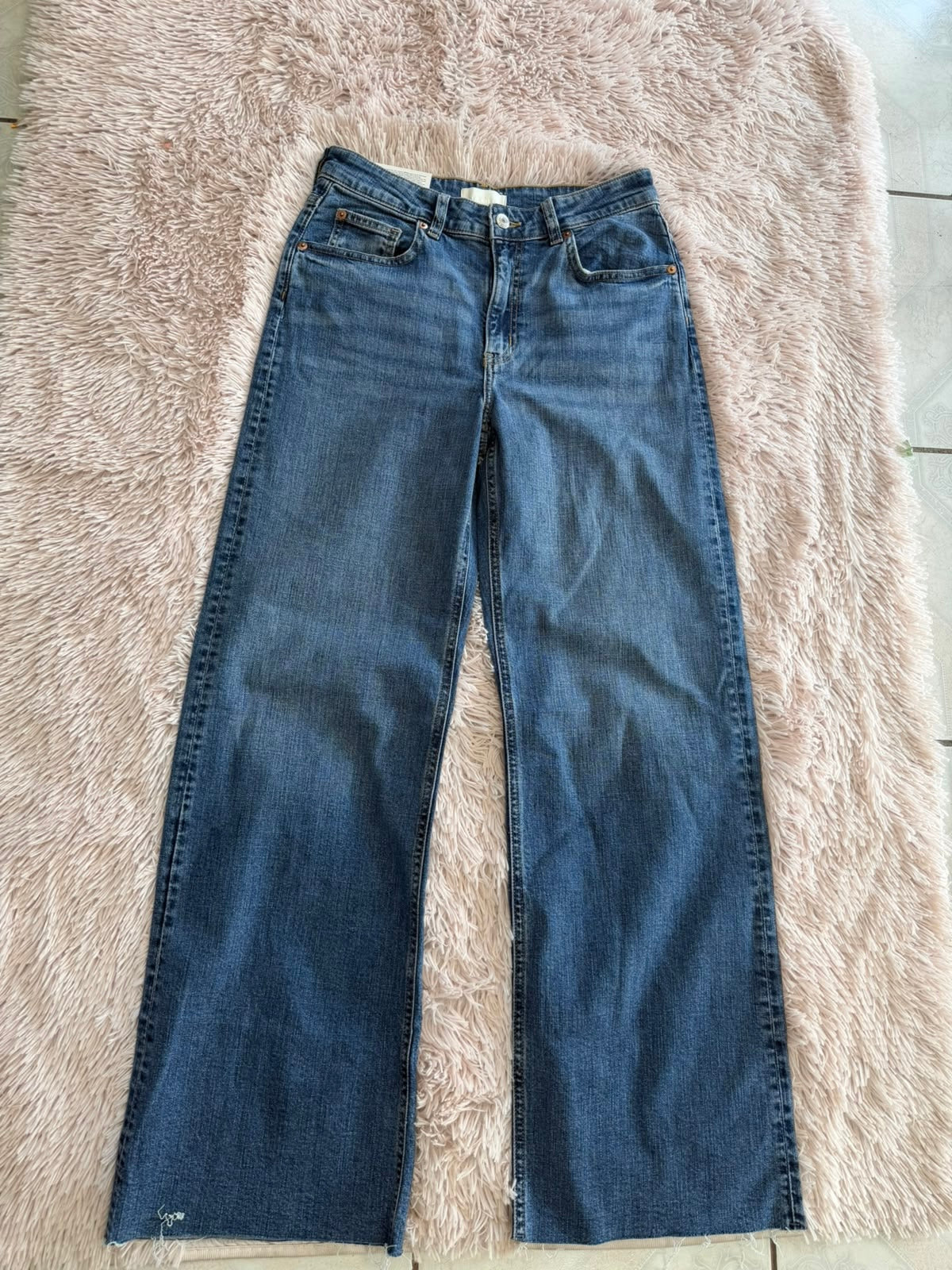 Jeans azul H&M de pierna amplia con bajo deshilachado